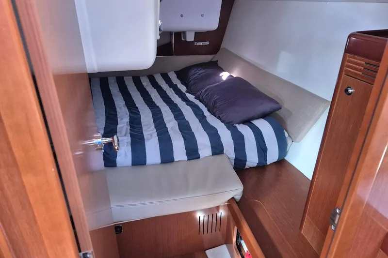 Serene Yacht Photos Pics Cozy cabin interior of 2011 Beneteau Oceanis 37 sailboat with striped bedding.