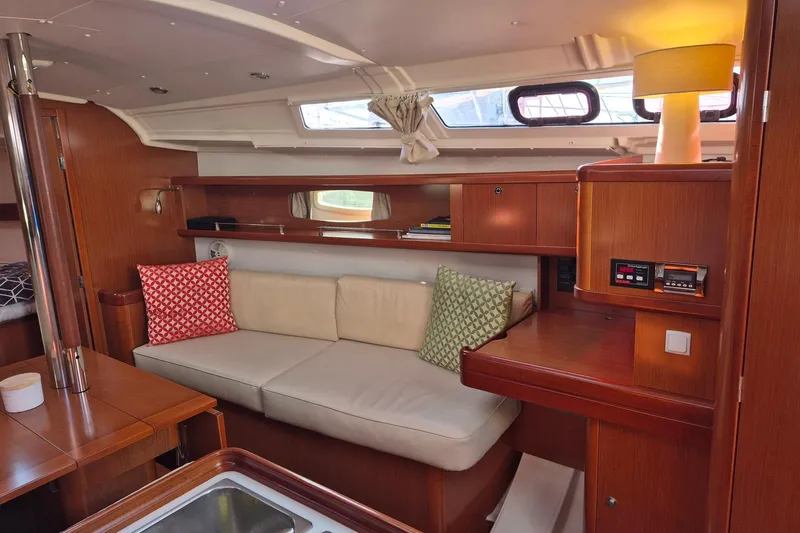Serene Yacht Photos Pics Interior of 2011 Beneteau Oceanis 37 yacht with cozy seating and wooden cabinetry.