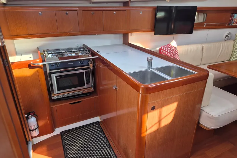 Serene Yacht Photos Pics Interior of 2011 Beneteau Oceanis 37 yacht with kitchen and seating area.