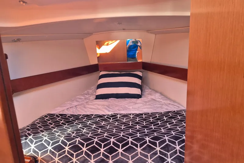 Serene Yacht Photos Pics Cozy cabin interior of 2011 Beneteau Oceanis 37 sailboat with striped pillow.