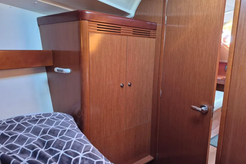 Serene Yacht Photos Pics Interior cabin of 2011 Beneteau Oceanis 37 yacht with wooden closet and bed.