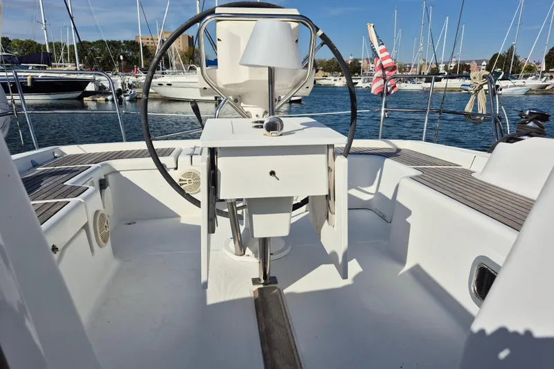 Serene Yacht Photos Pics Cockpit of 2011 Beneteau Oceanis 37 sailboat, featuring steering wheel and marina view.