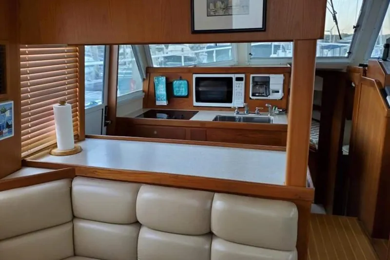 Good Chemistry Yacht Photos Pics 2001 Mainship 430 Trawler interior with kitchen and seating area.