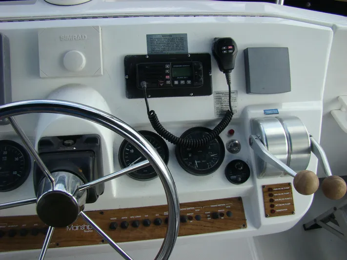 Good Chemistry Yacht Photos Pics Mainship 430 Trawler 2001 helm station with steering wheel, controls, and navigation equipment.