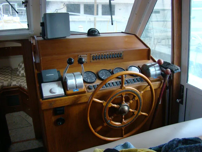Good Chemistry Yacht Photos Pics 2001 Mainship 430 Trawler helm station with wooden steering wheel and navigation controls.