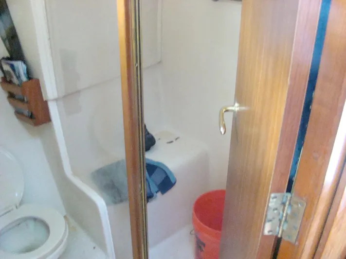 Good Chemistry Yacht Photos Pics 2001 Mainship 430 Trawler bathroom with toilet, shower, and storage.