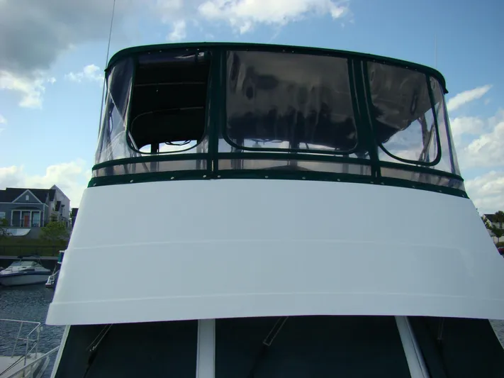 Good Chemistry Yacht Photos Pics 2001 Mainship 430 Trawler flybridge with clear enclosure, docked at marina.