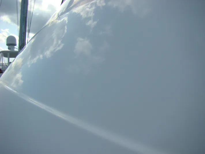 Good Chemistry Yacht Photos Pics Close-up of 2001 Mainship 430 Trawler hull reflecting sky and clouds.