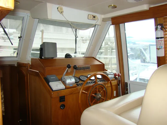Good Chemistry Yacht Photos Pics Mainship 430 Trawler 2001 helm station with wooden steering wheel and navigation equipment.