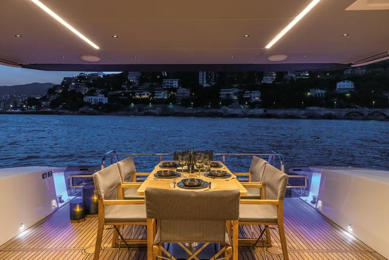  Yacht Photos Pics Luxurious dining setup on Absolute 60 Fly yacht, 2026, with scenic waterfront view at dusk.