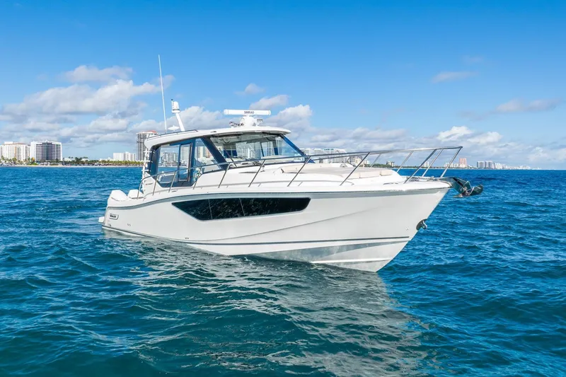 True Companion Yacht Photos Pics 2024 Boston Whaler 405 Conquest boat on blue ocean with city skyline background.