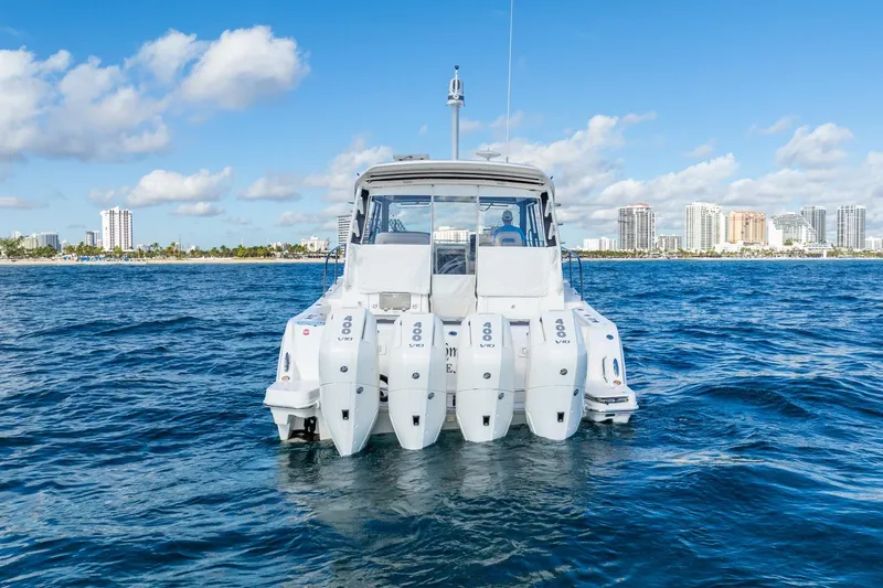 True Companion Yacht Photos Pics 2024 Boston Whaler 405 Conquest boat on ocean with city skyline background.