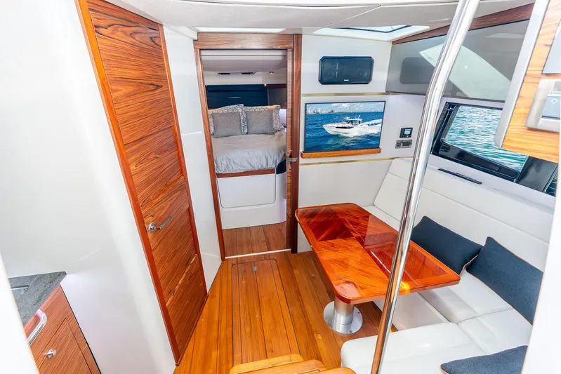 True Companion Yacht Photos Pics Luxurious interior of 2024 Boston Whaler 405 Conquest yacht with wood accents and cozy seating.