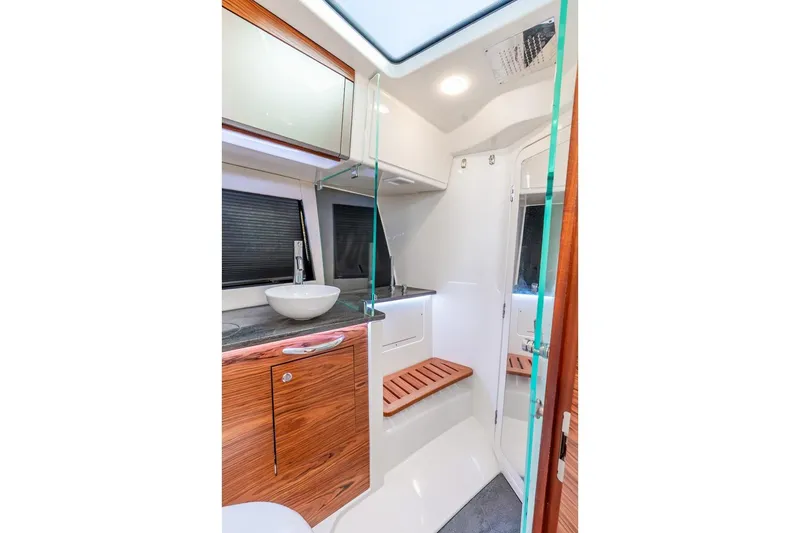 True Companion Yacht Photos Pics Luxurious bathroom interior of 2024 Boston Whaler 405 Conquest boat, featuring modern fixtures and wood accents.