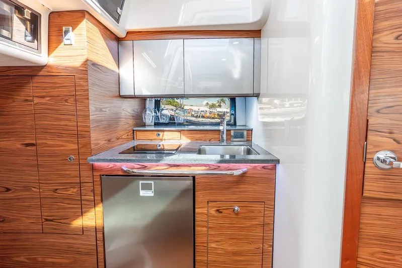 True Companion Yacht Photos Pics 2024 Boston Whaler 405 Conquest yacht kitchen with wood cabinetry and stainless steel appliances.