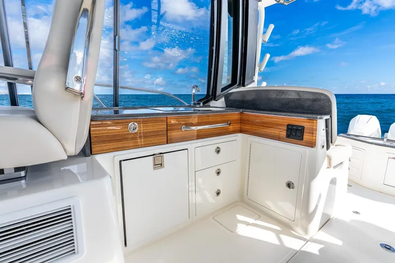 True Companion Yacht Photos Pics 2024 Boston Whaler 405 Conquest interior with ocean view, featuring sleek cabinetry and seating.