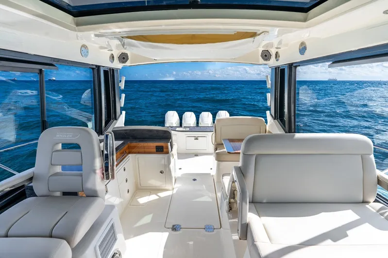 True Companion Yacht Photos Pics 2024 Boston Whaler 405 Conquest interior with ocean view, featuring luxurious seating and modern design.