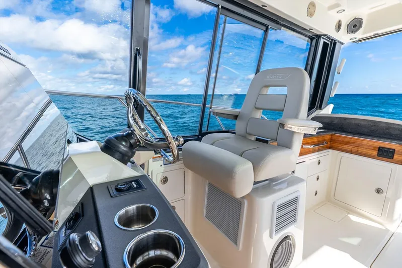 True Companion Yacht Photos Pics 2024 Boston Whaler 405 Conquest helm with ocean view, featuring luxurious seating and controls.