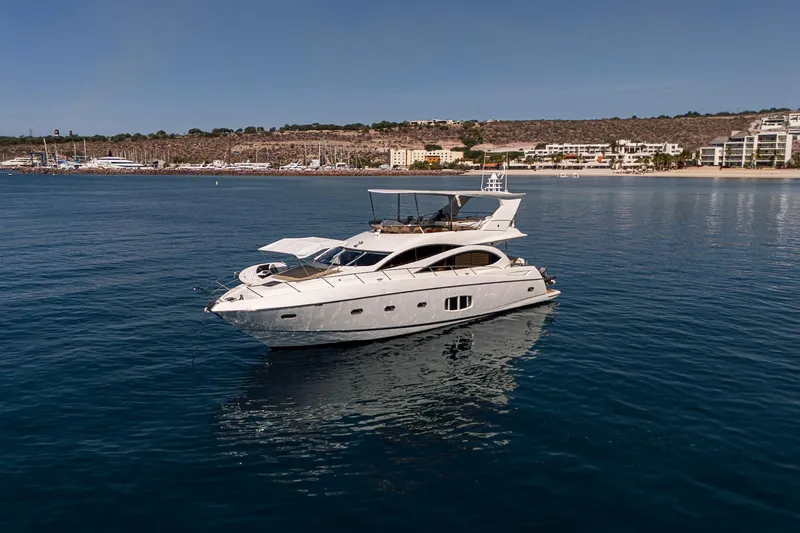 Bar&co Yacht Photos Pics Luxurious 2008 Sunseeker Manhattan 73 yacht on calm waters near a coastal town.