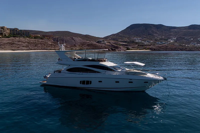 Bar&co Yacht Photos Pics 2008 Sunseeker Manhattan 73 yacht on calm waters near a scenic coastline.