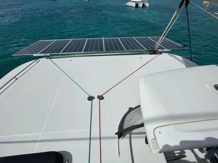 Evolution Yacht Photos Pics Lagoon 42 catamaran (2017) with solar panels on deck, anchored in clear blue water.
