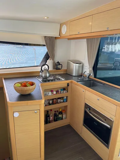 Evolution Yacht Photos Pics Modern kitchen interior of 2017 Lagoon 42 catamaran with wooden cabinets and appliances.