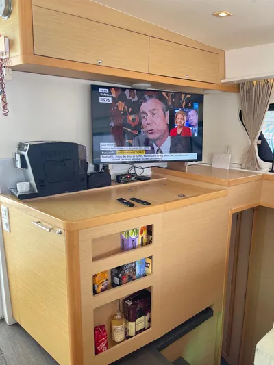 Evolution Yacht Photos Pics Interior of 2017 Lagoon 42 catamaran with TV, coffee maker, and storage shelves.
