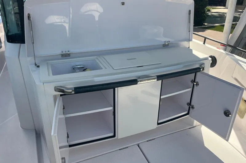 Sweet Spot Yacht Photos Pics 2021 Axopar 37 Cross Cabin boat kitchen area with open storage and sink.
