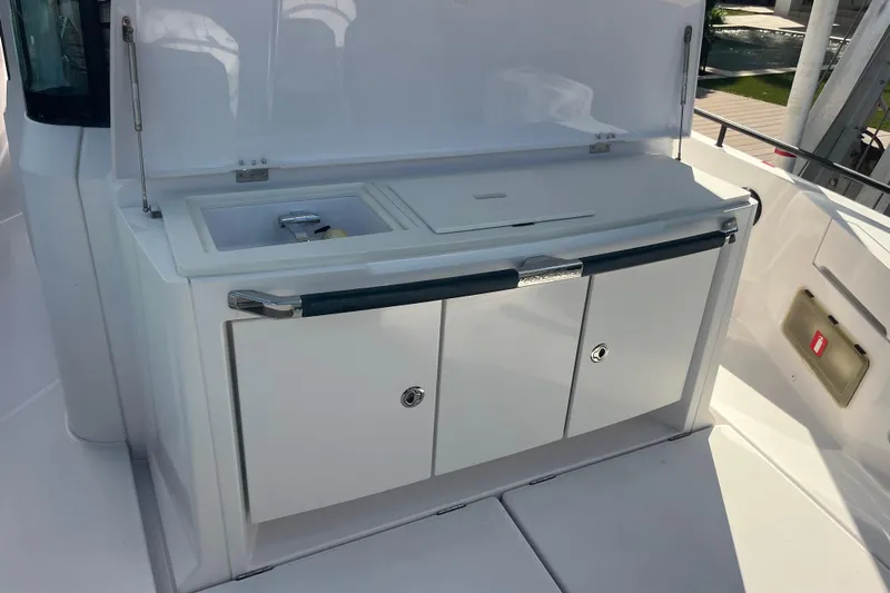 Sweet Spot Yacht Photos Pics 2021 Axopar 37 Cross Cabin boat kitchenette with sink and storage cabinets.