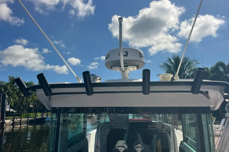 Sweet Spot Yacht Photos Pics 2021 Axopar 37 Cross Cabin boat with radar and rod holders under a blue sky.