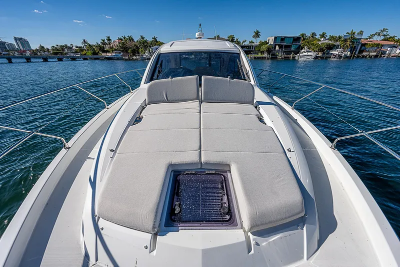  Yacht Photos Pics 2022 Beneteau Gran Turismo 45 yacht with sunbathing area on deck, docked in a marina.