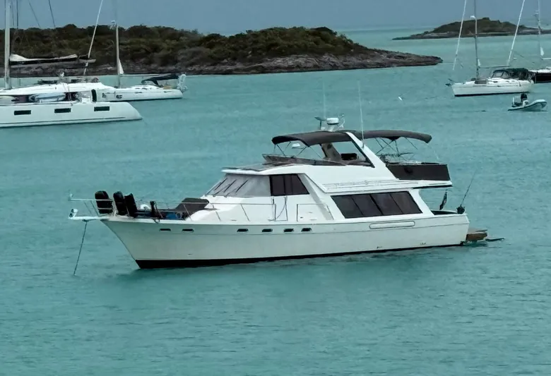 Seanergy III Yacht Photos Pics 1995 Bayliner 4788 Pilothouse Motoryacht anchored in turquoise waters, surrounded by other boats.