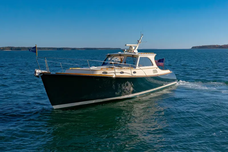 Charmer Yacht Photos Pics 1999 Hinckley Talaria 44 Express yacht cruising on open water under clear blue skies.