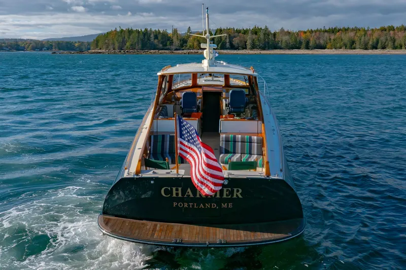 Charmer Yacht Photos Pics Hinckley Talaria 44 Express yacht, 1999, cruising in scenic waters with American flag.