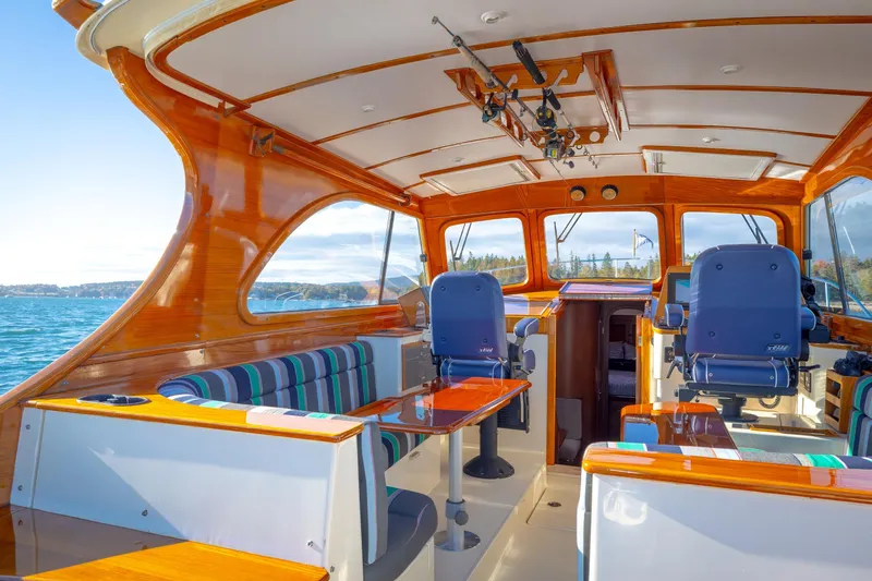 Charmer Yacht Photos Pics Interior of a 1999 Hinckley Talaria 44 Express yacht with polished wood and seating.