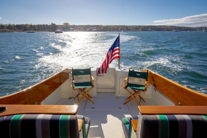 Charmer Yacht Photos Pics Hinckley Talaria 44 Express 1999 cruising on sunny waters with American flag.