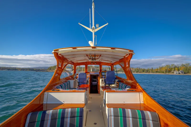 Charmer Yacht Photos Pics 1999 Hinckley Talaria 44 Express yacht on scenic water with clear blue sky.