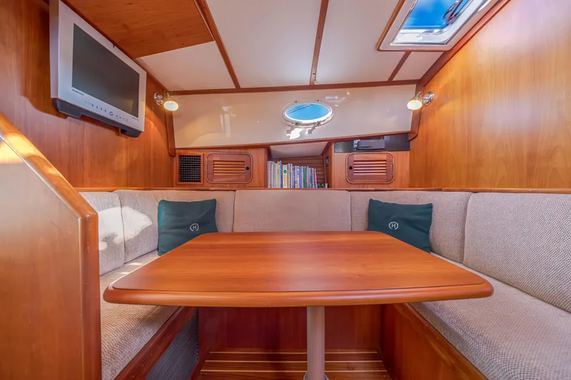 Charmer Yacht Photos Pics Interior of 1999 Hinckley Talaria 44 Express with cozy seating and wooden table.