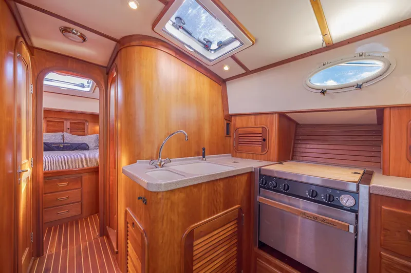 Charmer Yacht Photos Pics Interior of 1999 Hinckley Talaria 44 Express yacht with wood finish and kitchen amenities.
