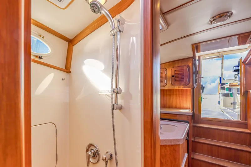 Charmer Yacht Photos Pics Interior of 1999 Hinckley Talaria 44 Express yacht, featuring a shower and wooden cabinetry.