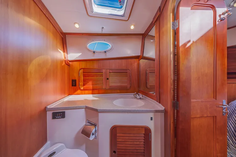Charmer Yacht Photos Pics Luxurious 1999 Hinckley Talaria 44 Express yacht bathroom with wood accents and skylight.