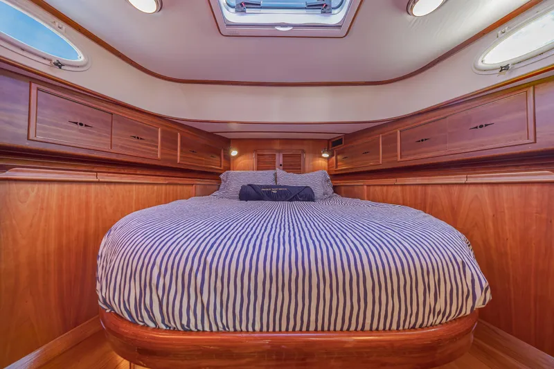 Charmer Yacht Photos Pics Luxurious cabin interior of 1999 Hinckley Talaria 44 Express yacht with striped bedding.