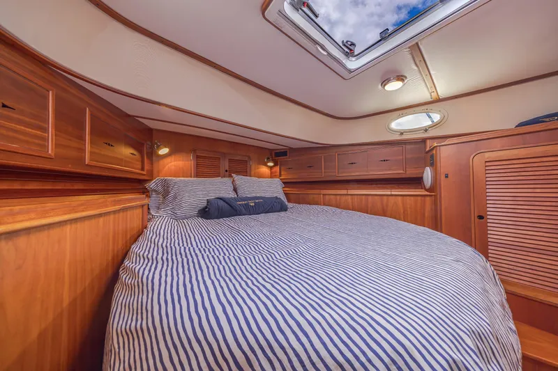 Charmer Yacht Photos Pics Luxurious cabin interior of 1999 Hinckley Talaria 44 Express yacht with striped bedding.