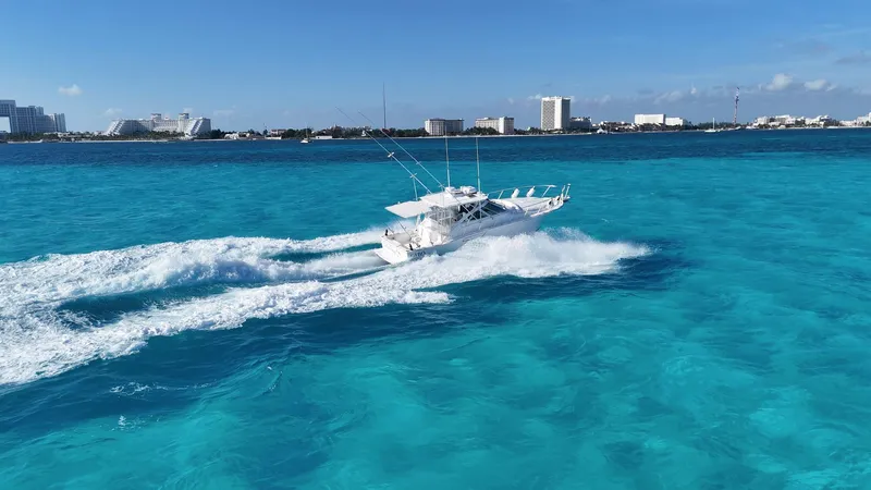 Siboney Yacht Photos Pics Cabo 40 Express 2004 on turquoise sea near coastal city.