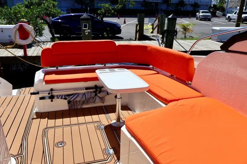  Yacht Photos Pics 2014 Azimut 38 yacht deck with orange seating and table, docked at marina.