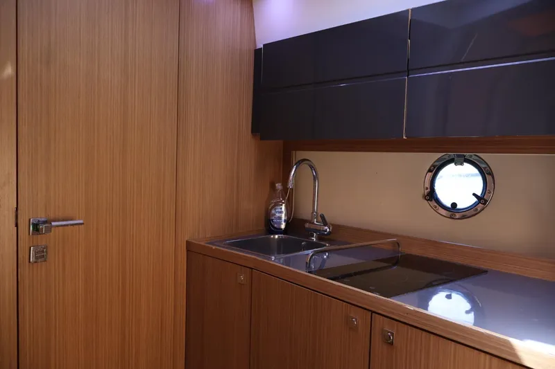  Yacht Photos Pics Luxurious kitchen interior of 2014 Azimut 38 yacht with sleek wood finish and porthole.