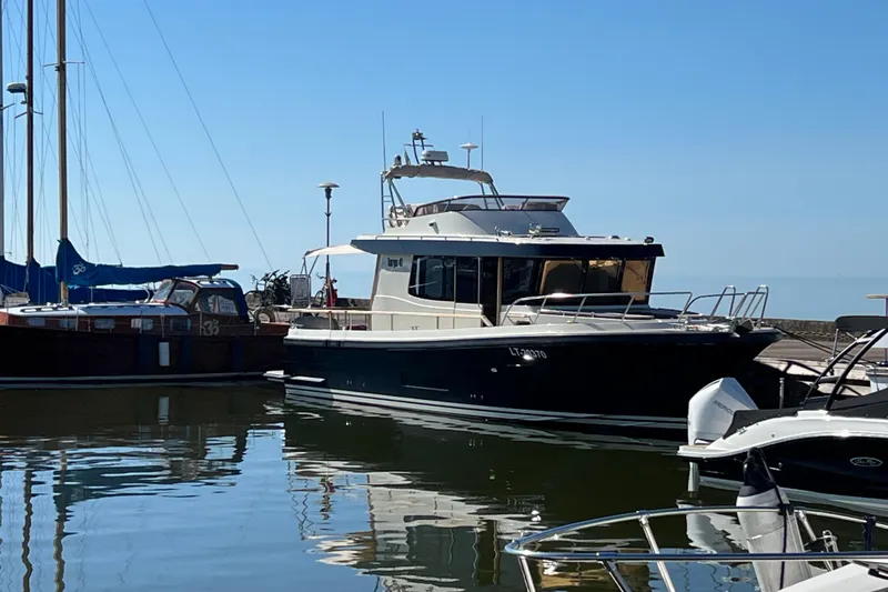  Yacht Photos Pics 2024 Targa 41 yacht docked in a serene marina under clear blue skies.