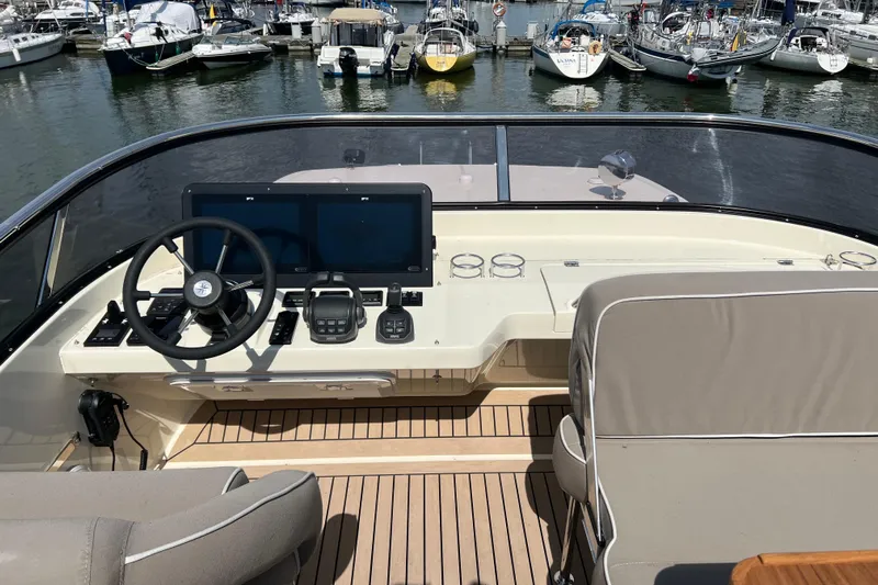  Yacht Photos Pics 2024 Targa 41 yacht helm with dual screens, steering wheel, and marina view.