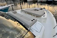 2017 Cranchi E 52 F yacht with sunbathing area, docked in a marina at sunset.
