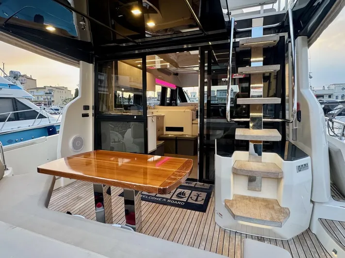  Yacht Photos Pics 2017 Cranchi E 52 F yacht interior with wooden table and staircase.